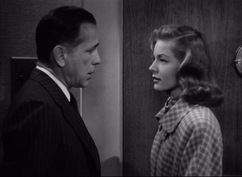 Movie still from “Dark Passage” (1947), directed by Delmer Daves – A man and a woman standing next to each other; Medium shot, Over the shoulder angle