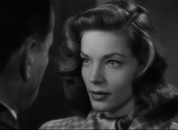 Movie still from “Dark Passage” (1947), directed by Delmer Daves – An old photo of a woman with a man looking at her; Close Up shot, Over the shoulder angle