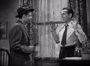Movie still from “Dark Passage” (1947), directed by Delmer Daves – Two men in suits and hats talking to each other; Medium shot, Low angle