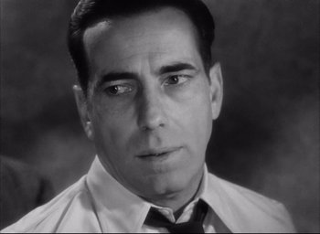 Movie still from “Dark Passage” (1947), directed by Delmer Daves – Black and white photograph of a man in a shirt and tie; Close Up shot, Low angle