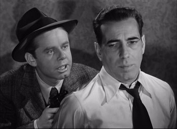 Movie still from “Dark Passage” (1947), directed by Delmer Daves – A man in a suit and a man in a tie; Close Up shot, Over the shoulder angle