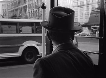 Movie still from “Dark Passage” (1947), directed by Delmer Daves – A black and white photo of a man wearing a hat; Close Up shot, Over the shoulder angle