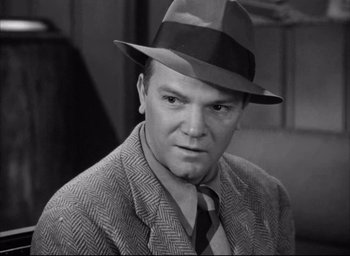 Movie still from “Dark Passage” (1947), directed by Delmer Daves – A man wearing a hat and a suit; Close Up shot, High angle