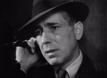 Movie still from “Dark Passage” (1947), directed by Delmer Daves – A black and white photo of a man talking on a cell phone; Close Up shot, Low angle