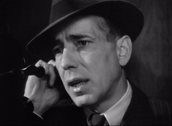 Movie still from “Dark Passage” (1947), directed by Delmer Daves – A black and white photo of a man talking on a cell phone; Close Up shot, Low angle