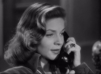 Movie still from “Dark Passage” (1947), directed by Delmer Daves – A woman talking on a phone while wearing a ring on her ring finger; Close Up shot, Low angle