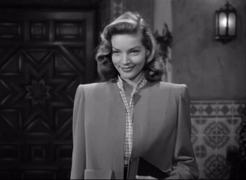 Movie still from “Dark Passage” (1947), directed by Delmer Daves – A black - and - white photo of a woman in a suit; Medium shot, Low angle