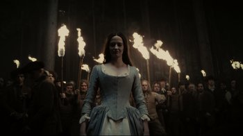 Movie still from “Dark Shadows” (2012), directed by Tim Burton – A group of people standing in front of lit torches; Medium shot, Low angle