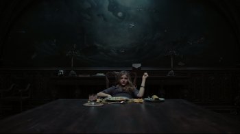 Movie still from “Dark Shadows” (2012), directed by Tim Burton – A woman sitting at a dinner table with a plate of food in front of her; Wide shot, High angle