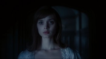 Movie still from “Dark Shadows” (2012), directed by Tim Burton – A young woman in a white shirt is looking at the camera; Close Up shot, Low angle