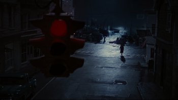 Movie still from “Dark Shadows” (2012), directed by Tim Burton – A red traffic light sitting on the side of a road; Extreme Wide shot, High angle