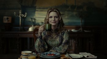 Movie still from “Dark Shadows” (2012), directed by Tim Burton – A woman sitting at a dinner table drinking a cup of coffee; Medium shot, Over the shoulder angle