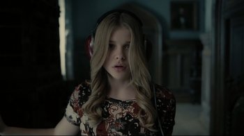 Movie still from “Dark Shadows” (2012), directed by Tim Burton – A young girl with long blonde hair wearing headphones; Close Up shot, Low angle