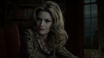 Movie still from “Dark Shadows” (2012), directed by Tim Burton – A woman with long blonde hair sitting in front of a book shelf; Close Up shot, Over the shoulder angle