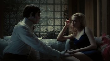 Movie still from “Dark Shadows” (2012), directed by Tim Burton – A man and a woman sitting on a couch in front of a window; Medium shot, High angle