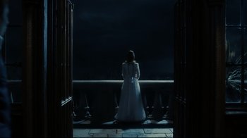 Movie still from “Dark Shadows” (2012), directed by Tim Burton – A woman in a white dress standing in front of a balcony; Wide shot, High angle