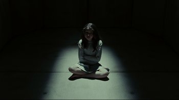 Movie still from “Dark Shadows” (2012), directed by Tim Burton – A woman sitting on the ground in a dark room; Medium shot, High angle
