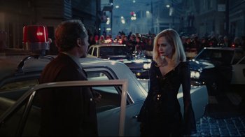 Movie still from “Dark Shadows” (2012), directed by Tim Burton – A man and a woman are standing next to each other in front of cars; Medium shot, Over the shoulder angle