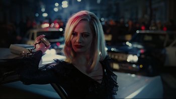 Movie still from “Dark Shadows” (2012), directed by Tim Burton – A woman holding a cell phone while standing next to a car at night; Close Up shot, Over the shoulder angle