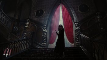 Movie still from “Dark Shadows” (2012), directed by Tim Burton – A woman standing on the stairs in front of a window; Wide shot, Low angle