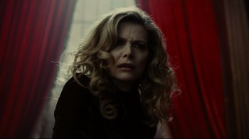 Movie still from “Dark Shadows” (2012), directed by Tim Burton – A woman with long blonde curly hair wearing a black shirt; Close Up shot, Low angle
