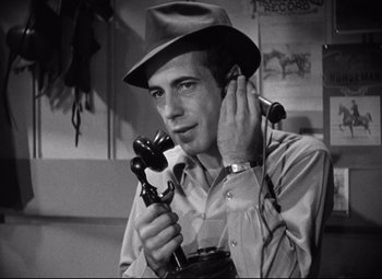 Movie still from “Dark Victory” (1939), directed by Edmund Goulding – A black and white photo of a man holding a phone; Close Up shot, Low angle