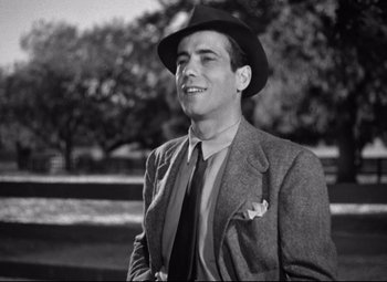 Movie still from “Dark Victory” (1939), directed by Edmund Goulding – A black and white photo of a man wearing a suit and hat; Medium shot, Low angle