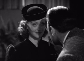 Movie still from “Dark Victory” (1939), directed by Edmund Goulding – A woman wearing a hat looking at a man in a suit; Close Up shot, Over the shoulder angle