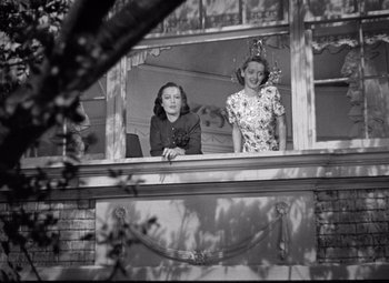 Movie still from “Dark Victory” (1939), directed by Edmund Goulding – Two women standing on a balcony looking out of a window; Wide shot, Low angle