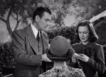 Movie still from “Dark Victory” (1939), directed by Edmund Goulding – A man and a woman standing next to each other in front of another woman; Medium shot, High angle
