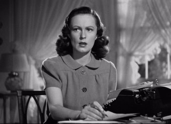 Movie still from “Dark Victory” (1939), directed by Edmund Goulding – A woman sitting at a table with a typewriter; Close Up shot, Low angle
