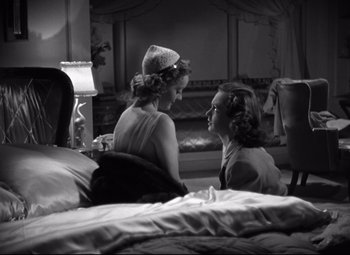 Movie still from “Dark Victory” (1939), directed by Edmund Goulding – Two women sitting on a bed talking to each other; Medium shot, High angle