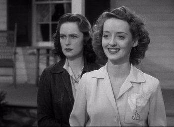 Movie still from “Dark Victory” (1939), directed by Edmund Goulding – A couple of women standing next to each other on a street; Close Up shot, Low angle