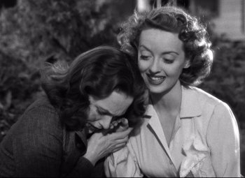 Movie still from “Dark Victory” (1939), directed by Edmund Goulding – Two women are embracing and smiling for the camera; Close Up shot, Over the shoulder angle
