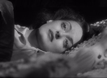 Movie still from “Dark Victory” (1939), directed by Edmund Goulding – A black and white photo of a woman laying in a bed; Close Up shot, Overhead angle
