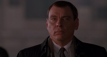 Movie still from “Darkman” (1990), directed by Sam Raimi – A person wearing a suit and tie; Close Up shot, Low angle