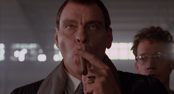 Movie still from “Darkman” (1990), directed by Sam Raimi – A person holding a cigar in his mouth; Close Up shot, Low angle
