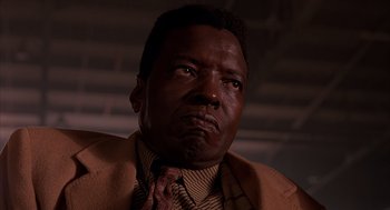 Movie still from “Darkman” (1990), directed by Sam Raimi – A person wearing a suit and a tie; Close Up shot, Low angle