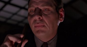 Movie still from “Darkman” (1990), directed by Sam Raimi – A person holding a cell phone; Close Up shot, Low angle