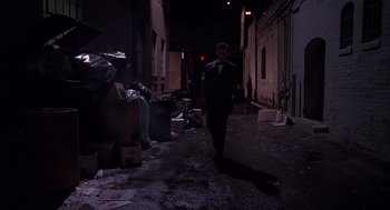 Movie still from “Darkman” (1990), directed by Sam Raimi – A man walking down a street at night; Wide shot, High angle