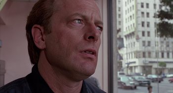 Movie still from “Darkman” (1990), directed by Sam Raimi – A man's face in front of a window; Close Up shot, Low angle