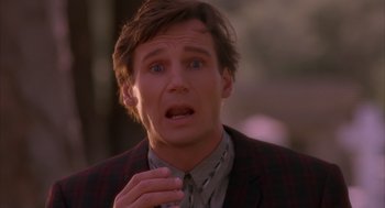 Movie still from “Darkman” (1990), directed by Sam Raimi – A person wearing a suit and tie; Close Up shot, Over the shoulder angle