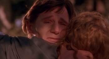 Movie still from “Darkman” (1990), directed by Sam Raimi – A man holding a woman's face in front of a window; Close Up shot, Over the shoulder angle