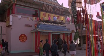 Movie still from “Darkman” (1990), directed by Sam Raimi – A group of people walking in front of a restaurant; Extreme Wide shot, High angle