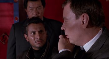 Movie still from “Darkman” (1990), directed by Sam Raimi – A group of men standing next to each other in a room; Close Up shot, Over the shoulder angle