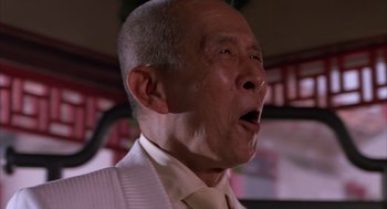 Movie still from “Darkman” (1990), directed by Sam Raimi – An older man in a white shirt and a yellow tie; Close Up shot, Low angle