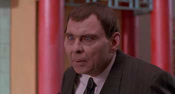 Movie still from “Darkman” (1990), directed by Sam Raimi – A man in a suit and tie with blue eyes; Close Up shot, Low angle