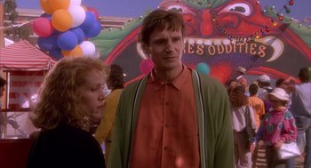 Movie still from “Darkman” (1990), directed by Sam Raimi – A man and a woman standing next to each other in front of balloons; Medium shot, Low angle