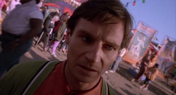 Movie still from “Darkman” (1990), directed by Sam Raimi – A man's face in front of a group of people; Close Up shot, High angle