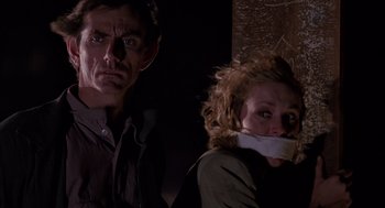 Movie still from “Darkman” (1990), directed by Sam Raimi – A man and a woman with their mouths taped shut; Close Up shot, Low angle